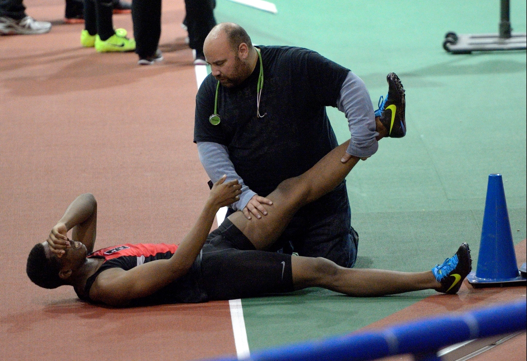 man holding athlete's feet on the ground