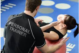 Trainer assisting woman